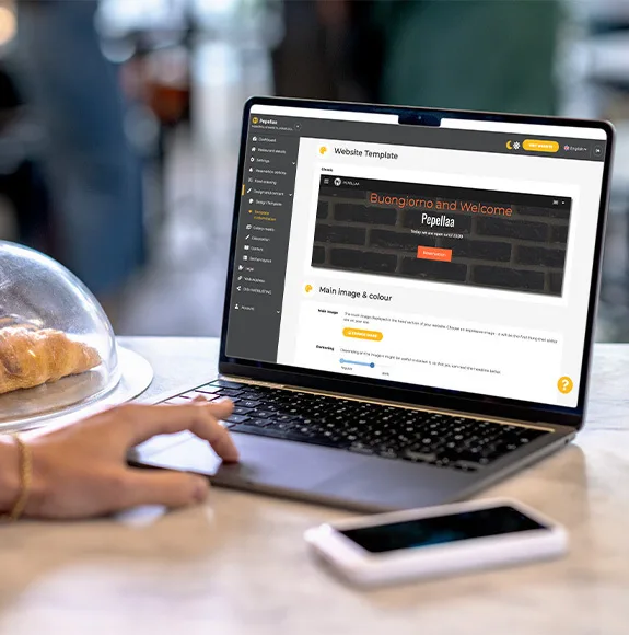 Detailní záběr na notebook s otevřenou webovou stránkou restaurace s digitálním menu.