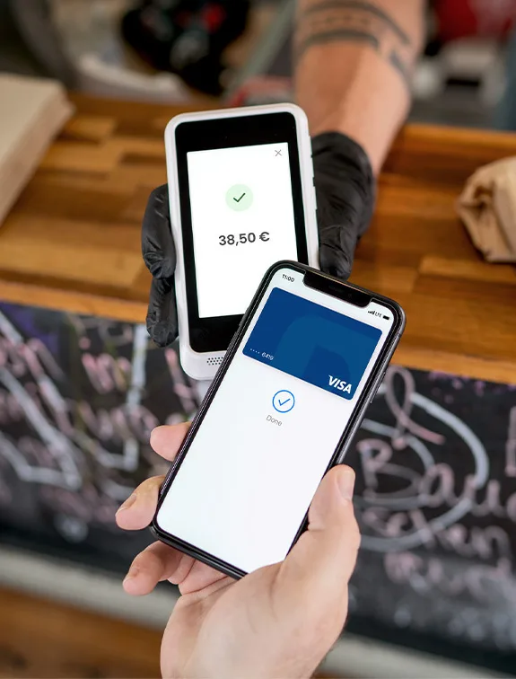 Close-up of contactless payment with smartphone at a payment terminal; successful transaction displayed.