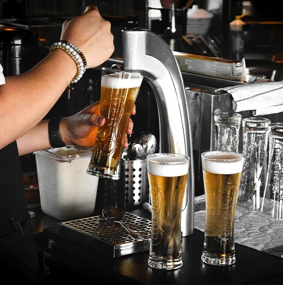 Tap system in a bar where fresh beer is poured into glasses.