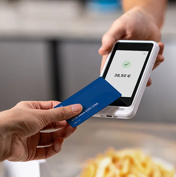 Primo piano: pagamento contactless su un terminale di pagamento con un dispositivo mobile, importo visibile.