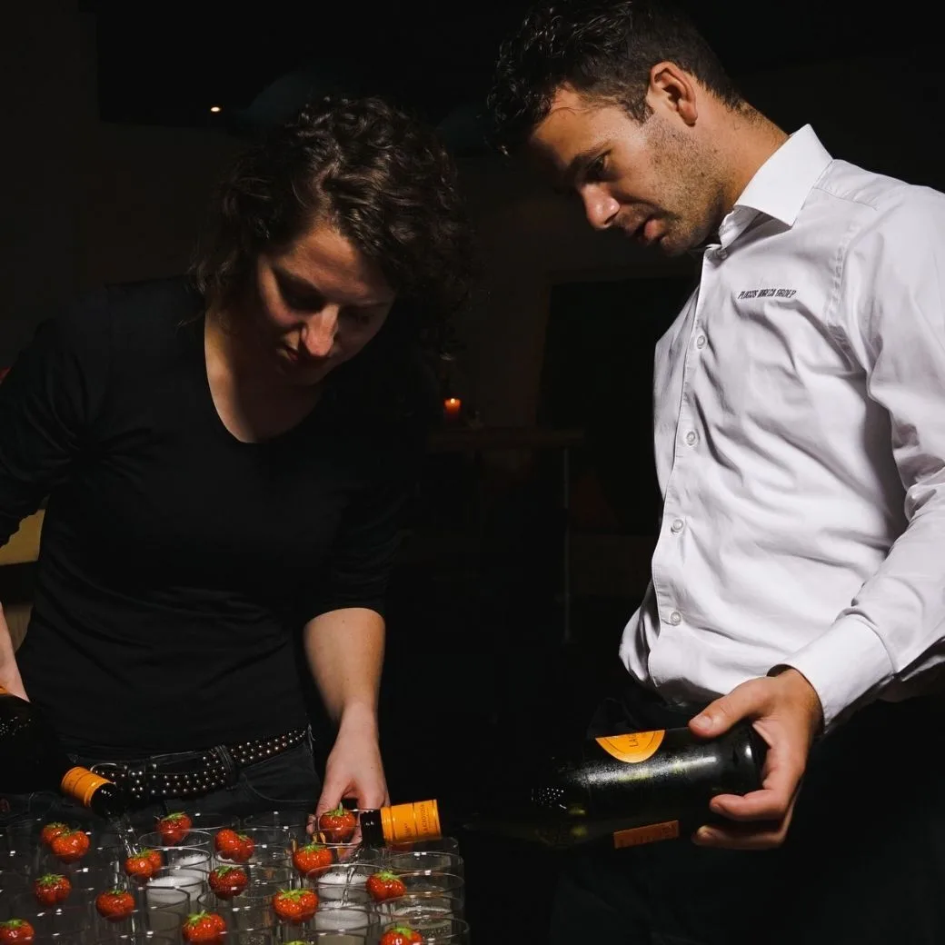 Gastvrouw gastheer inschenken aperitief